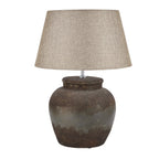 Table lamp with textured brown base and beige lampshade on a white background