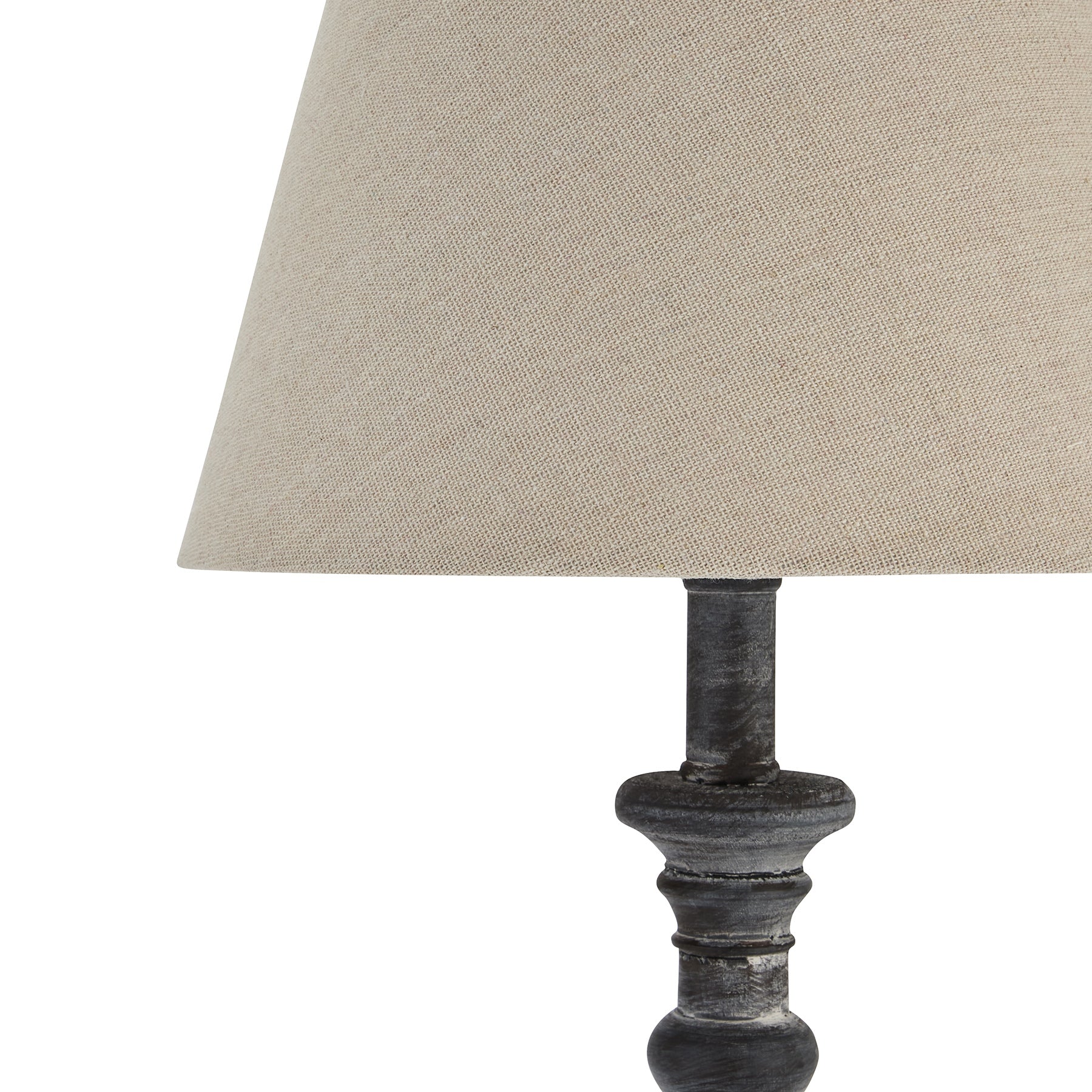 Table lamp with a textured base and beige fabric shade on a white background