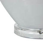 Close-up of a white glass table lamp with a clear base on a white background