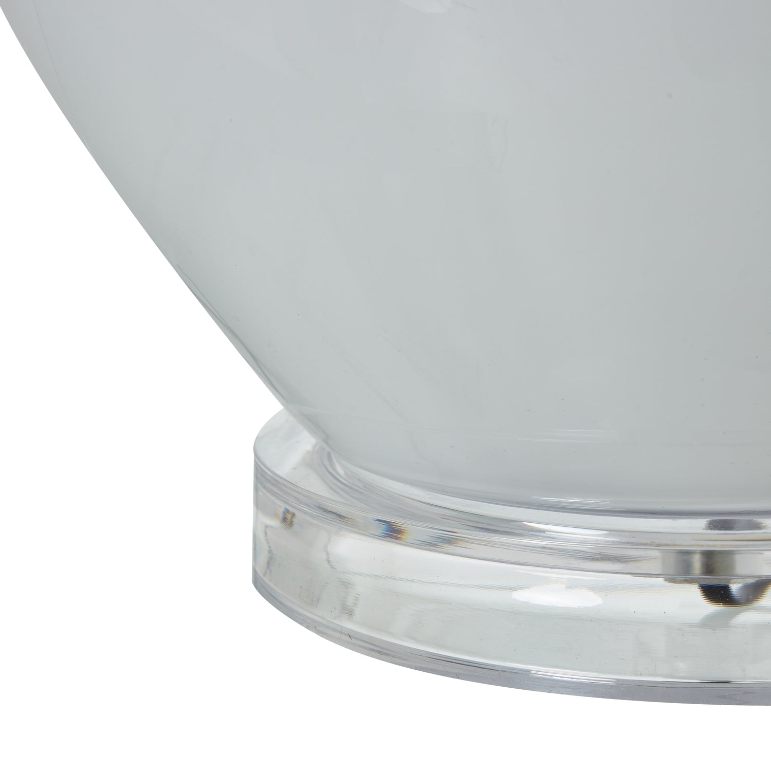 Close-up of a white glass table lamp with a clear base on a white background