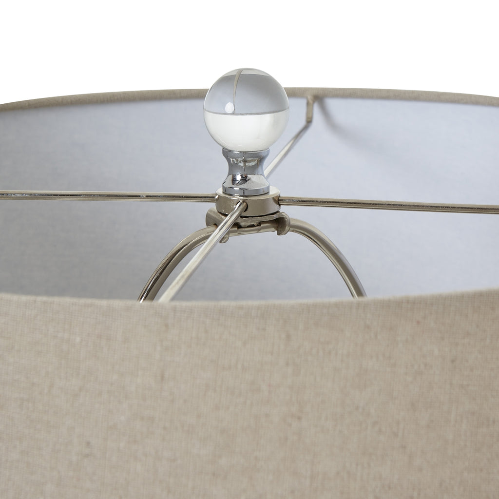 Close-up of a lampshade with a beige shade and metallic base.