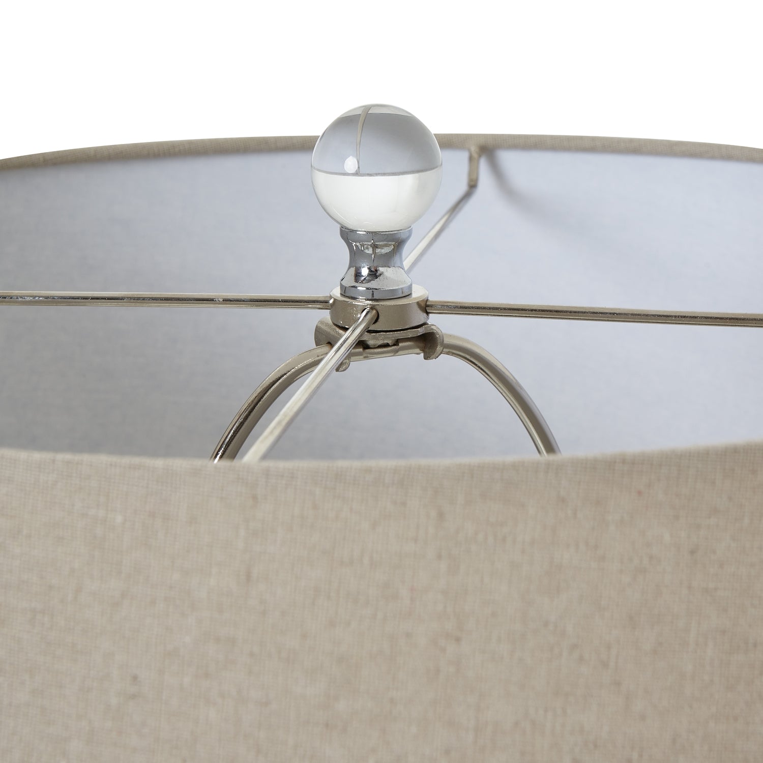 Close-up of a lampshade with a beige shade and metallic base.
