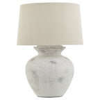 Table lamp with a textured white base and cream lampshade on a white background
