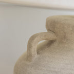 Close-up of a textured ceramic vase with a blurred background