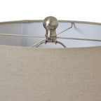 Close-up of a lampshade with a cream fabric shade and metallic fixture.
