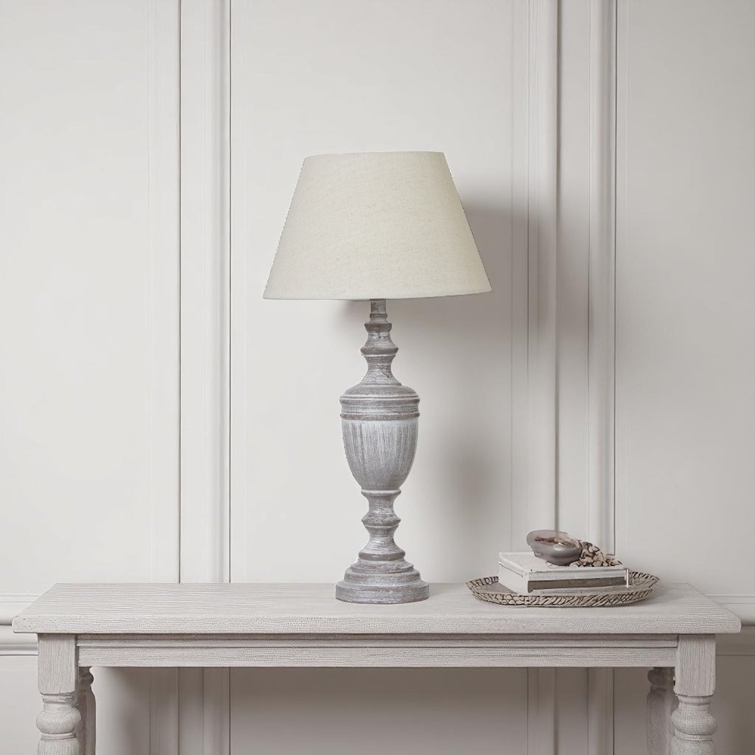 Table lamp on a wooden table against a white paneled wall