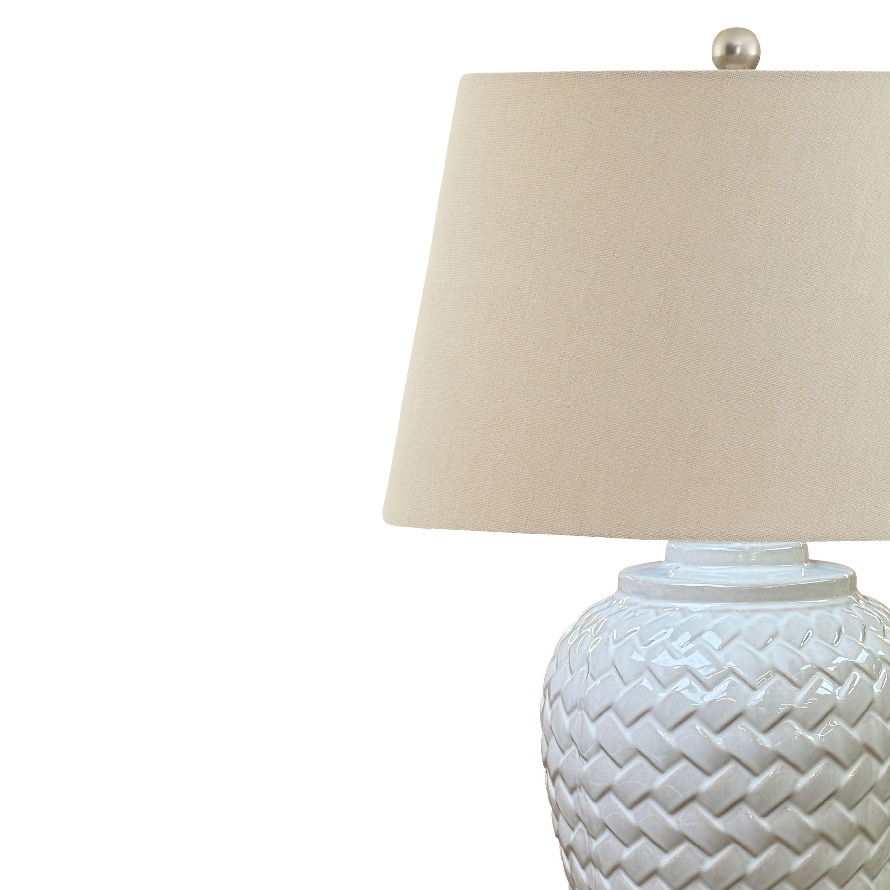 Table lamp with woven design base and cream lampshade on a white background
