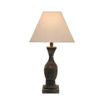 Table lamp with a textured brown base and beige lampshade on a white background