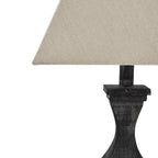Table lamp with a textured beige shade and dark wooden base on a white background