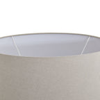 Close-up of a lampshade with a white inner rim and beige outer fabric.