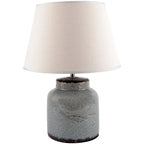 Table lamp with textured blue base and cream lampshade on a white background