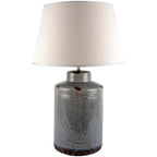 Table lamp with a textured ceramic blue base and cream lampshade on a white background